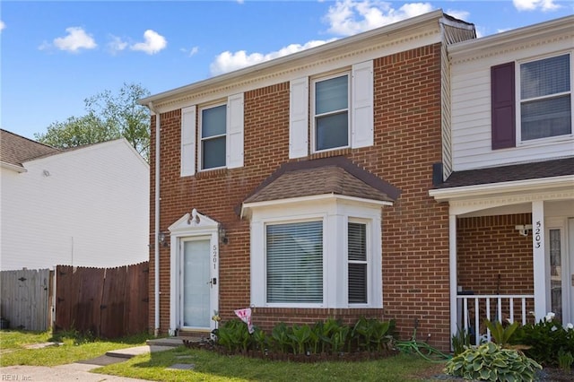 townhome / multi-family property featuring brick siding and fence