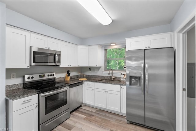 2050 Midway Ave, Chesapeake, VA 23324 - kitchen with a sink, light wood-style floors, dark stone countertops, stainless steel appliances, and white cabinetry