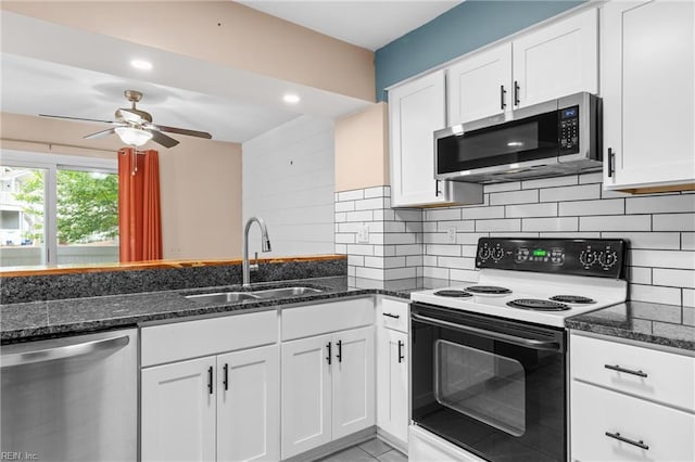 kitchen with appliances with stainless steel finishes, a sink, a ceiling fan, dark stone counters, and recessed lighting