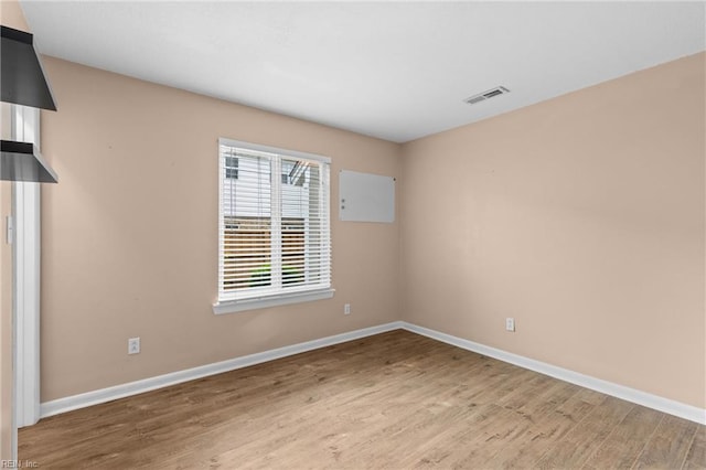 spare room featuring wood finished floors and baseboards