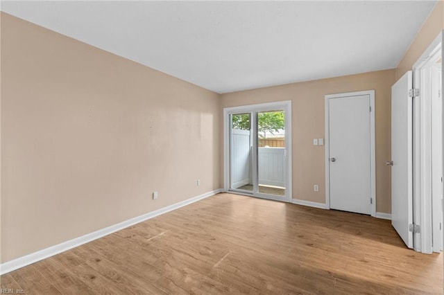 empty room with light wood-style flooring and baseboards