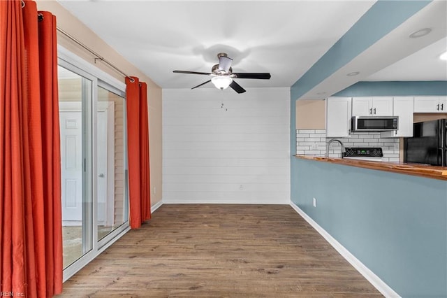 kitchen with black appliances, a ceiling fan, white cabinetry, tasteful backsplash, and baseboards