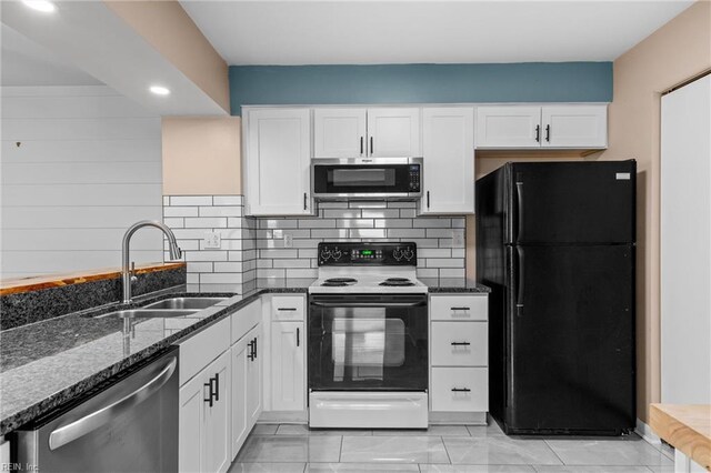 kitchen featuring appliances with stainless steel finishes, a sink, dark stone countertops, and white cabinets