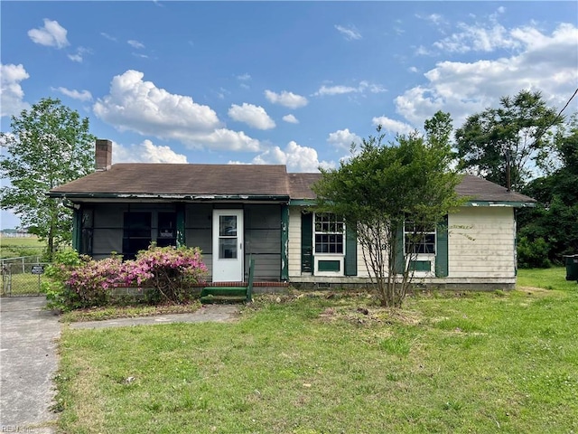 single story home featuring a chimney, fence, and a front yard