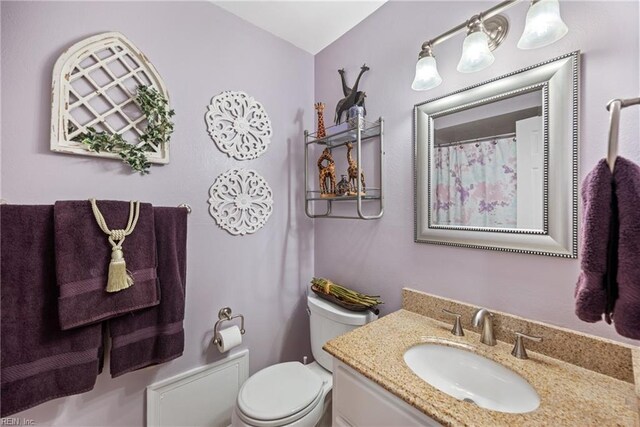 full bathroom with toilet and vanity