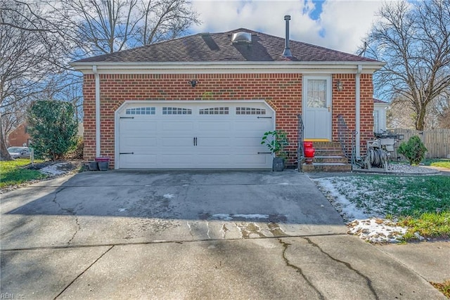 view of front of property featuring fence, an attached garage, concrete driveway, and brick siding