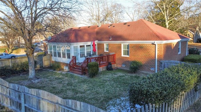 rear view of house with a fenced backyard, a wooden deck, a yard, and crawl space