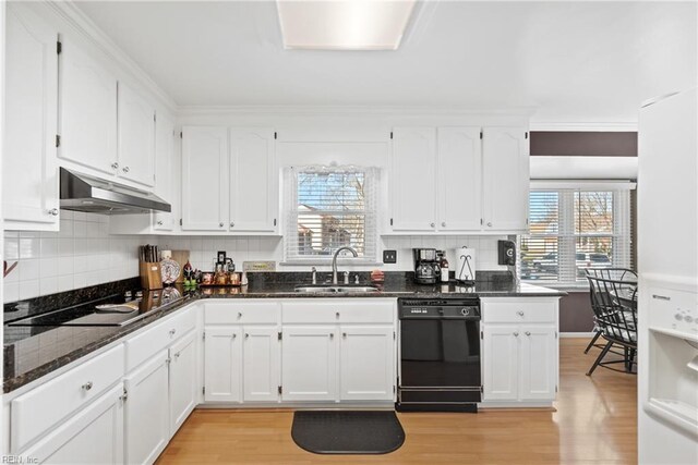 kitchen featuring light wood-style floors, under cabinet range hood, white cabinets, a sink, and black appliances
