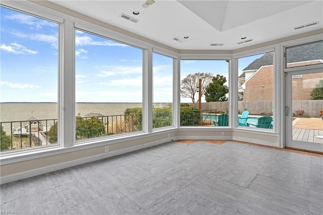 unfurnished sunroom with a healthy amount of sunlight, baseboards, and visible vents