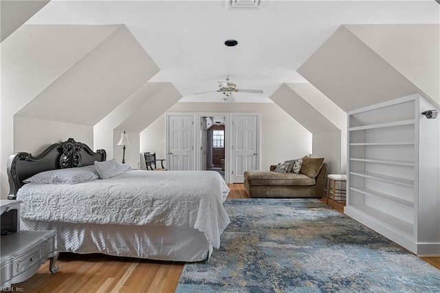 bedroom with ceiling fan, wood finished floors, and visible vents