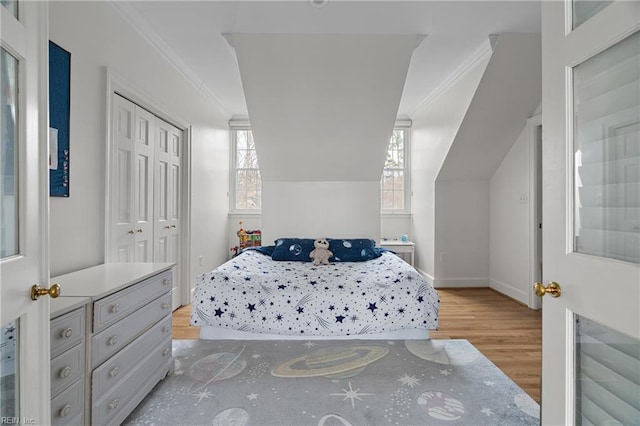 bedroom featuring ornamental molding, multiple windows, and wood finished floors