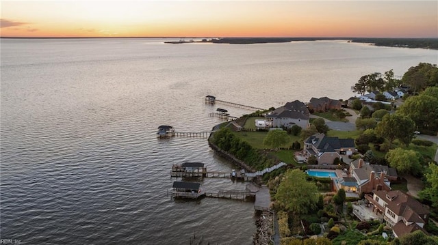 aerial view at dusk featuring a water view