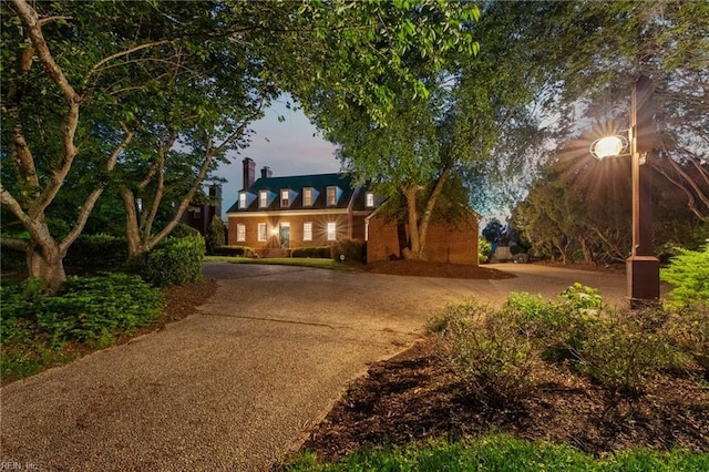 cape cod-style house with curved driveway