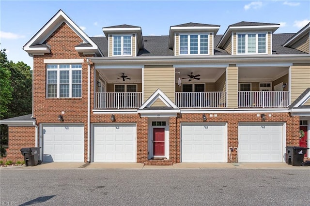 view of front of property featuring brick siding, ceiling fan, a balcony, and a garage