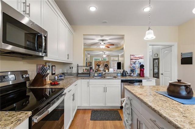 kitchen featuring a sink, white cabinetry, a ceiling fan, light wood-style flooring, and appliances with stainless steel finishes