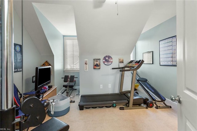 workout area featuring baseboards, carpet, and vaulted ceiling