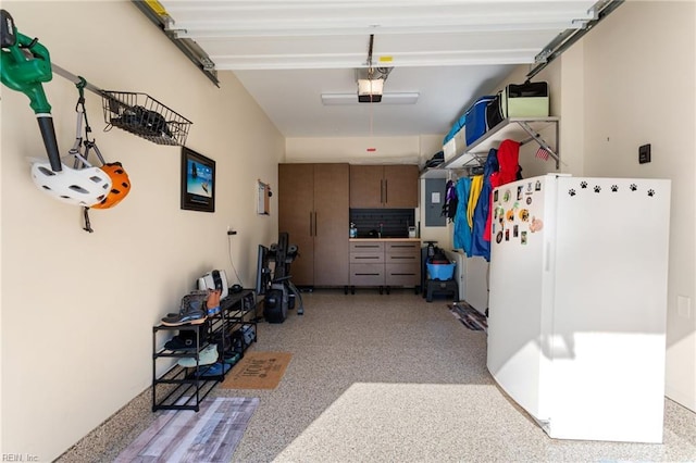 garage with freestanding refrigerator and a garage door opener