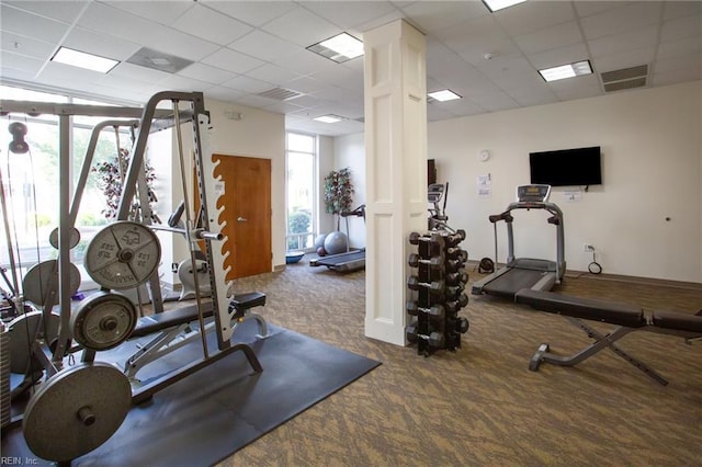 gym featuring carpet flooring, ornate columns, a paneled ceiling, and visible vents