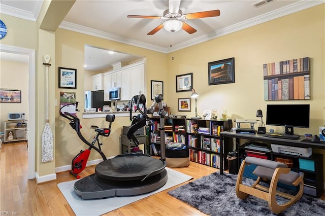 office featuring crown molding, a ceiling fan, baseboards, and wood finished floors