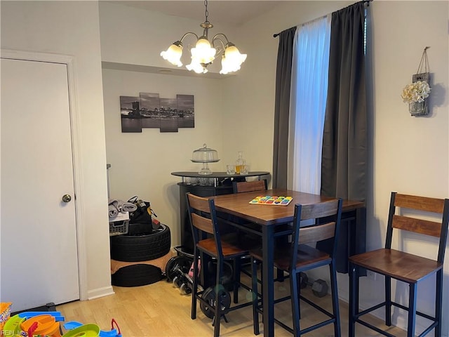 dining space with wood finished floors and a notable chandelier