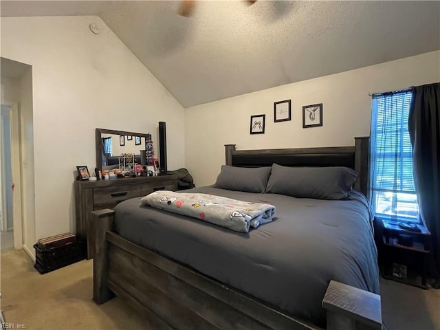 carpeted bedroom with a textured ceiling, ceiling fan, and vaulted ceiling