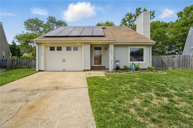 ranch-style home featuring a garage, roof mounted solar panels, a front yard, and concrete driveway