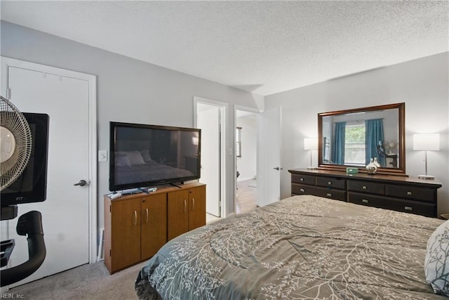 carpeted bedroom with a textured ceiling and connected bathroom