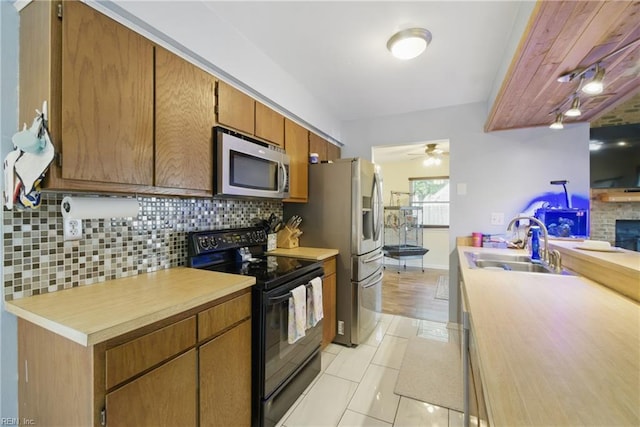 kitchen featuring a sink, appliances with stainless steel finishes, backsplash, and light countertops