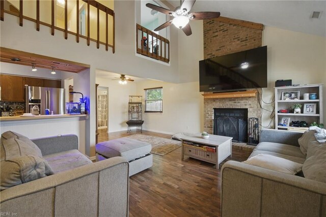 living area with visible vents, dark wood-style flooring, ceiling fan, and a fireplace