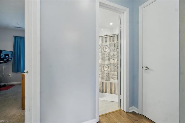 hallway with baseboards and wood finished floors