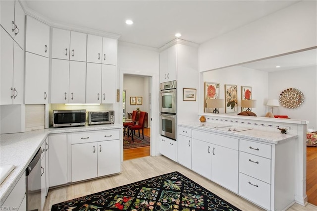 kitchen featuring appliances with stainless steel finishes, light wood-style flooring, a peninsula, white cabinets, and recessed lighting