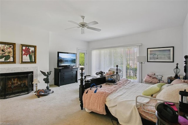 bedroom featuring carpet floors, access to exterior, a premium fireplace, and ceiling fan