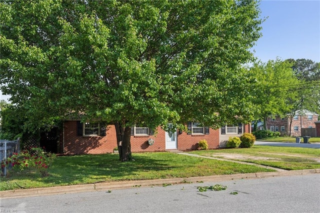 2015 Neville Cir, Hampton, VA 23663 - view of property hidden behind natural elements featuring brick siding, a front lawn, and fence