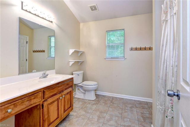 full bathroom featuring healthy amount of natural light, toilet, vanity, baseboards, and vaulted ceiling