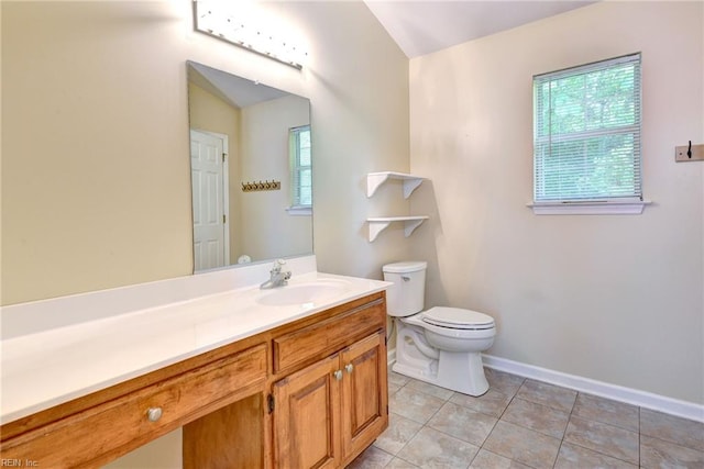 bathroom with toilet, tile patterned flooring, vanity, and baseboards