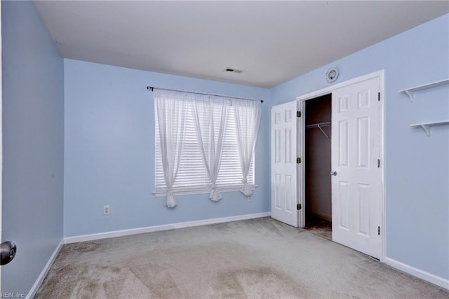 unfurnished bedroom with carpet floors, baseboards, and a closet