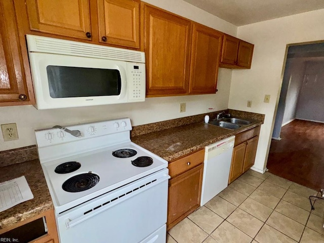 1528 Darren Cir, Portsmouth, VA 23701 - kitchen featuring white appliances, light tile patterned floors, brown cabinetry, and a sink