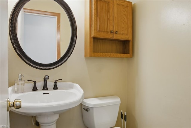half bathroom featuring toilet and a sink