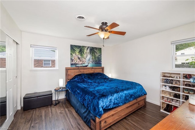 bedroom featuring visible vents, baseboards, wood finished floors, and multiple windows