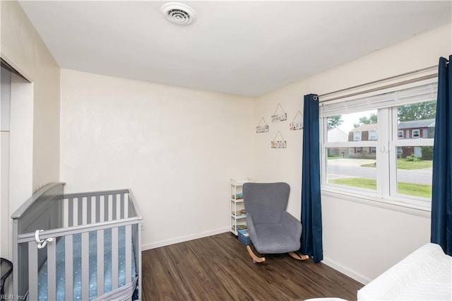 unfurnished bedroom featuring baseboards, visible vents, and wood finished floors