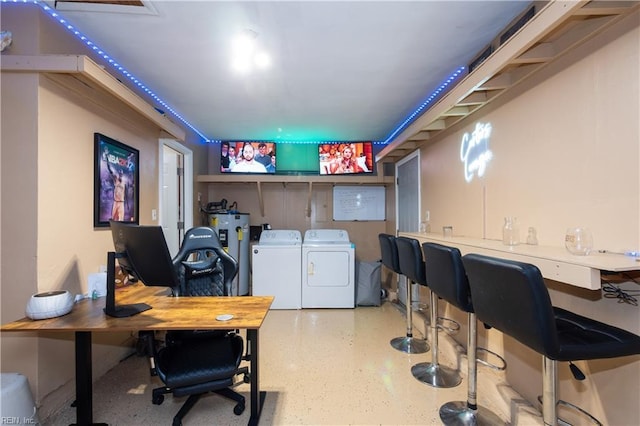 interior space featuring speckled floor, washing machine and clothes dryer, and electric water heater
