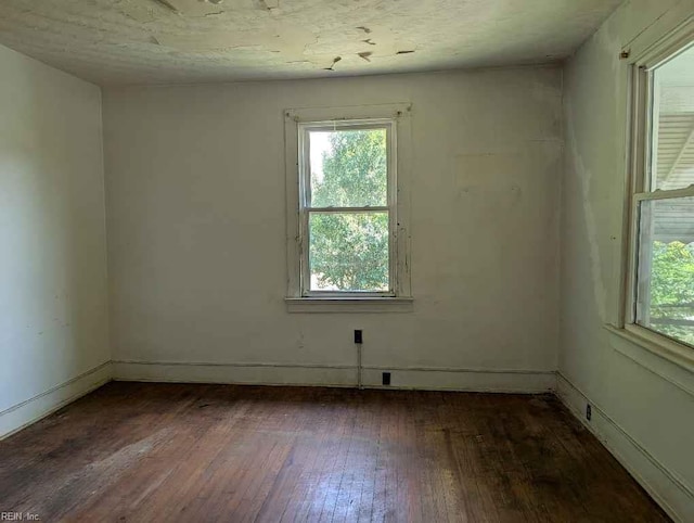unfurnished room featuring baseboards and hardwood / wood-style floors
