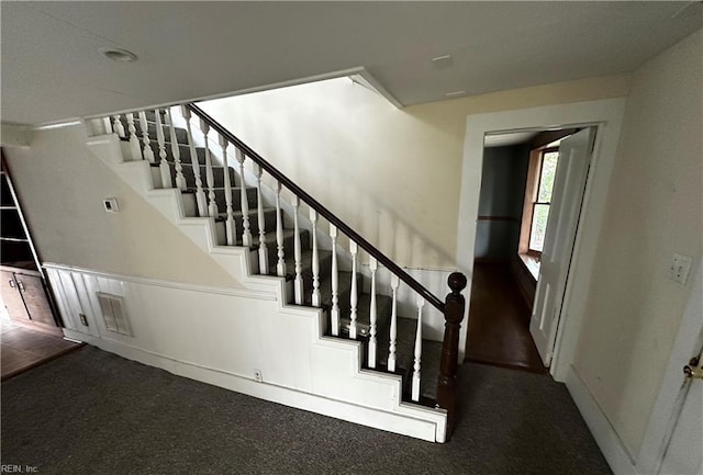 staircase with carpet floors, baseboards, and visible vents