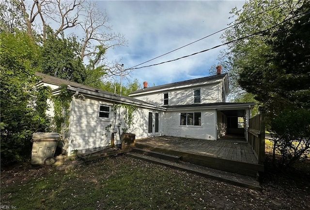 back of house featuring a chimney and a deck