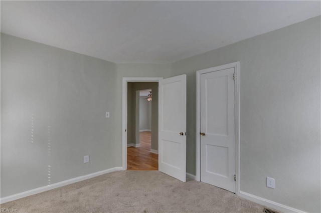 carpeted spare room featuring baseboards