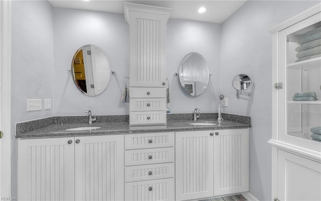 full bath with double vanity, recessed lighting, and a sink