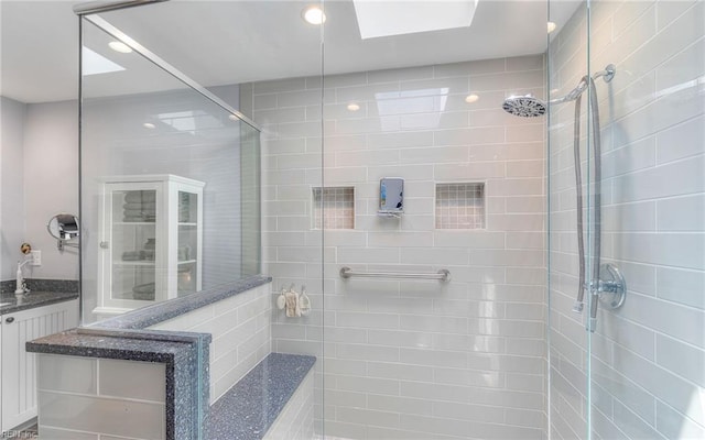 bathroom featuring recessed lighting, tiled shower, and vanity
