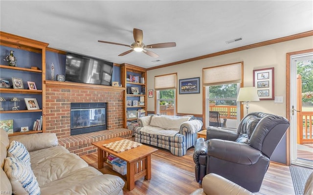 living area featuring ornamental molding, a ceiling fan, wood finished floors, and visible vents