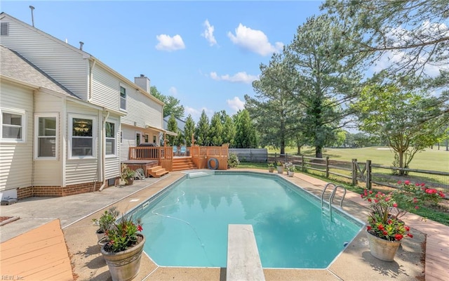 view of pool featuring a diving board, a wooden deck, a fenced in pool, a fenced backyard, and a patio