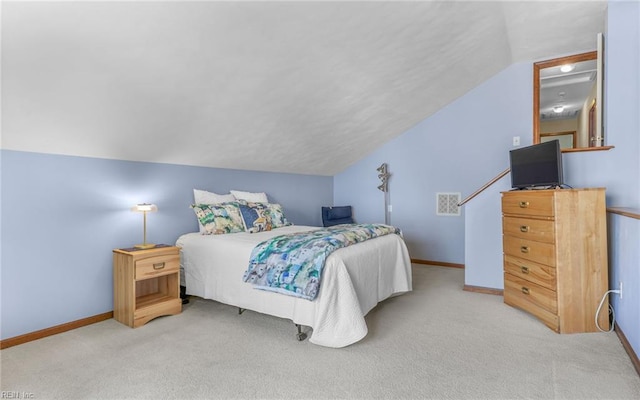 bedroom with light colored carpet, baseboards, and vaulted ceiling